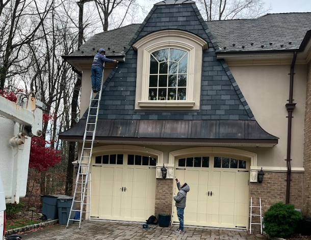 Brightness Window cleaning team hanging christmas decorations after cleaning a customers home windows.